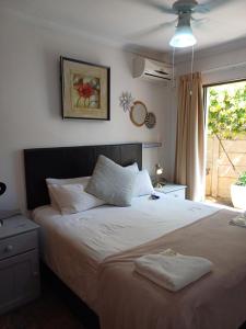 布隆方丹Cura Lodge的一间卧室配有一张大床和两条毛巾