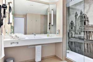 施韦夏特维也纳机场会议中心NH酒店的一间带水槽和淋浴的浴室