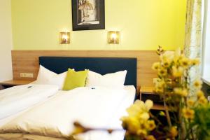瓦尔德纳布河畔诺伊施塔特格拉德酒店的一间卧室配有一张带白色床单和黄色墙壁的床。