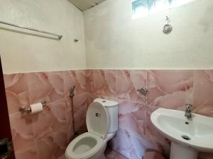 巴顿港Villa Milanel Port Barton的粉红色的浴室设有卫生间和水槽