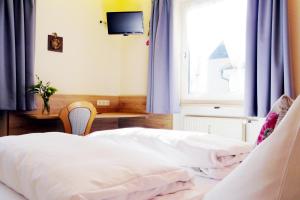 瓦尔德纳布河畔诺伊施塔特格拉德酒店的一间卧室配有两张带蓝色窗帘的床和电视。