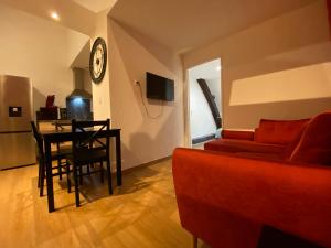 沃苏勒Appartements Baron Bouvier的客厅配有红色沙发和餐桌