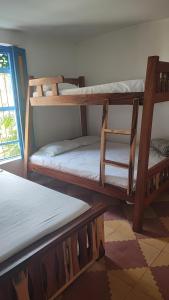 瓜塔佩Hotel sol del lago的客房设有三张双层床和一扇窗户。