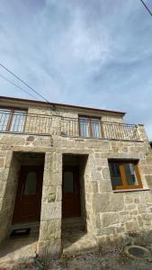 派瓦新镇Covo Residence - Casa Santiago的石头房子的顶部设有阳台