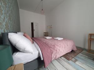 布拉迪斯拉发WE STAY APARTMENTS的一间卧室配有一张带粉色毯子和枕头的床。