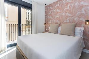 马拉加Apartamentos 7 dreams的卧室设有一张白色大床和一扇窗户。