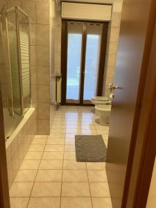 诺瓦拉Appartamento ONE的一间带卫生间、浴缸和门的浴室