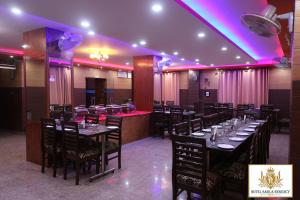 库尔卢Hotel Sarla Regency的一间配备有桌椅和紫色照明的用餐室