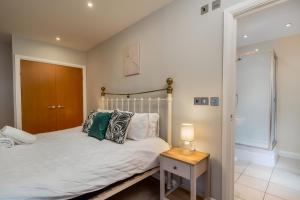 沃特福德Spacious Penthouse - Sleeps 6, Ideal for Contractors, Families & Business Travellers - Free Parking的一间卧室配有一张床和一张带台灯的桌子
