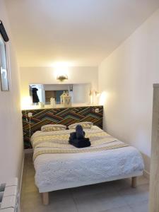Basse-IndreLA PETITE MAISON TAHET, 2 pers avec terrasse的一间卧室,配有一张床,上面有帽子