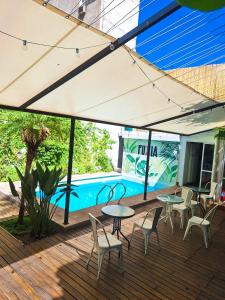 门多萨Fuxia Jungle Hostel的一个带桌椅的庭院和一个游泳池