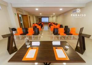 皮乌拉Hoteles Paraiso PIURA的一间会议室,配有橙色和黑色的椅子和桌子