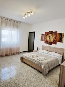 科米索Vincenti's House Comiso的一间白色客房内配有一张大床的卧室
