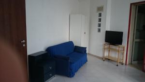 加利波利Baia Verde的客厅里的一张蓝色椅子,配有电视