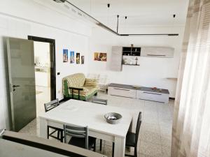 科米索Vincenti's House Comiso的厨房以及带桌椅的起居室。