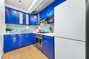 伦敦Balcony Blue Theme 1 Bedroom Central London Luxury Flat Near Hyde Park! Accommodates up to 6! Double Sofa Bed and Next to Station!的蓝色的厨房,配有白色的柜台和蓝色的橱柜