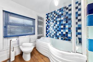 伦敦Balcony Blue Theme 1 Bedroom Central London Luxury Flat Near Hyde Park! Accommodates up to 6! Double Sofa Bed and Next to Station!的浴室配有卫生间、浴缸和水槽。