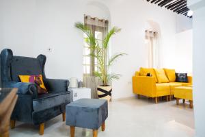 Stone TownPili Pili Kahawa House的客厅配有2把蓝色椅子和1把黄色椅子