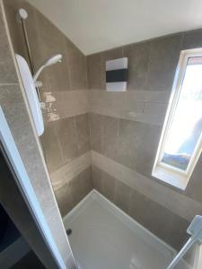 诺丁汉Quiet cosy 1 bedroom apartment Carrington F1的浴室配有带浴缸的大型淋浴