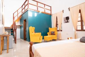 Stone TownPili Pili Kahawa House的一间卧室配有一张床和两张黄色椅子