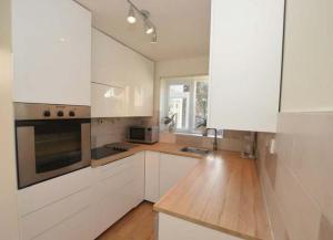 圣奥尔本斯Cosy & Peaceful 3B Home in Sandridge, St Albans的厨房配有白色橱柜和木制台面