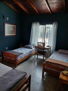 布卡拉曼加Tatami Hostel的一间卧室设有两张床、一张桌子和一个窗口。