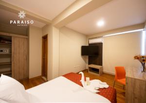 皮乌拉Hoteles Paraiso PIURA的配有一张床和一台平面电视的酒店客房