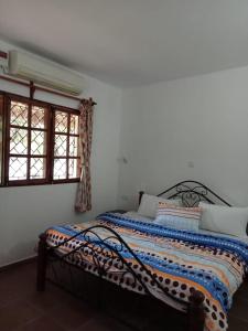 马林迪Karibuni Villa - Malindi beach view property的卧室配有床,位于带2个窗户的房间