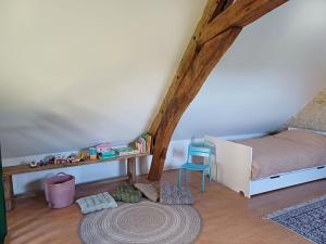 ChampfleurLa Garencière - La Petite Maison的一间卧室配有一张床、一张桌子和一张地毯。