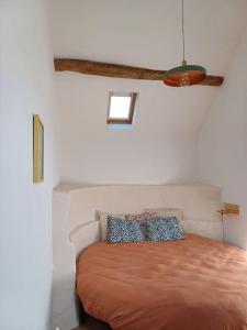 ChampfleurLa Garencière - La Petite Maison的一间卧室配有一张带棕色床罩的床