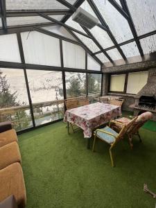 泰托沃Chalet Hilltop Kodra e Diellit Popovo Sapka的大楼内带桌椅的用餐室