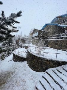 泰托沃Chalet Hilltop Kodra e Diellit Popovo Sapka的一座有积雪覆盖的院子,里面有一座建筑和一棵树