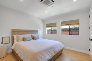 圣巴巴拉Villa Castillo 4的白色卧室设有一张大床和两个窗户
