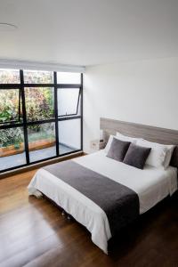 马尼萨莱斯Hotel Piedras De Maní的一间卧室设有一张大床和一个大窗户
