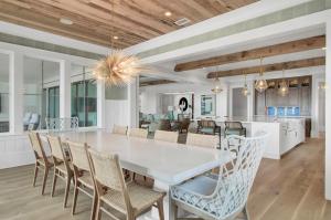 棕榈岛3108 Palm by AvantStay Oceanfront Private Pool Incredible Views的厨房以及带白色桌椅的用餐室。