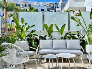 莫特里尔Aguacate Beach Apartamentos Playa Granada的天井配有沙发、桌子和植物