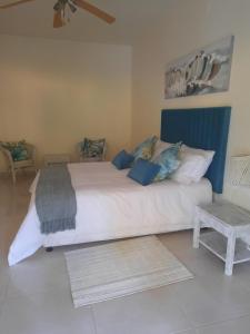 蓬塔杜欧鲁Tropicana guesthouse的卧室配有一张蓝色色调的大型白色床。