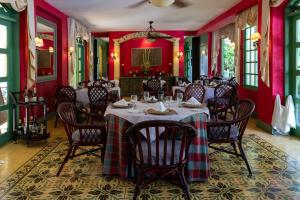 图里亚尔瓦Hotel Casa Turire的一间拥有红色墙壁和桌椅的用餐室