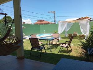 维拉维尔哈Casa pertinho da praia com piscina, wifi;的一个带桌椅的庭院和一个游泳池