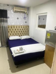 卡塔赫纳Del Castillo Mirador Hostel的小卧室配有一张带蓝色床罩和滚轮的床