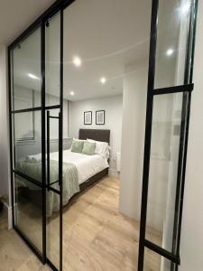 伦敦Luxury Capella Court的一间卧室设有一张床和玻璃墙