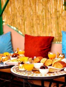 Fès al BaliRiad Dar Barae的一张桌子,上面放着不同类型的面包和橙汁