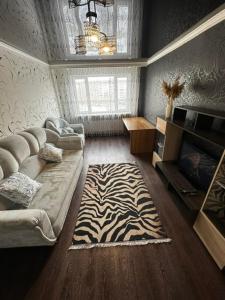 卡拉甘达Квартира по Республике 16/2的客厅配有沙发和斑马地毯