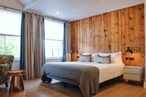 伦敦The Brownswood的一间卧室配有一张带木墙和窗户的床。