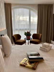 蒙托邦Dali Hôtel Montauban的酒店客房,配有一张带书籍和椅子的床