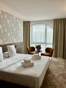 蒙托邦Dali Hôtel Montauban的一间卧室配有一张大床和两条毛巾