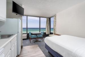 巴拿马城海滩比基尼海滩度假酒店的酒店客房设有一张床铺和一张桌子,享有美景。