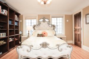 安娜堡石屋住宿加早餐酒店的卧室配有一张白色的床和大型床头板