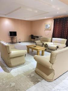 阿布贾Citilodge Hotel & Conference Centre的带沙发、桌子和电视的客厅