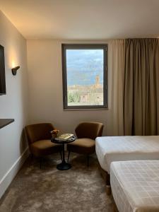 蒙托邦Dali Hôtel Montauban的酒店客房设有两张床和窗户。